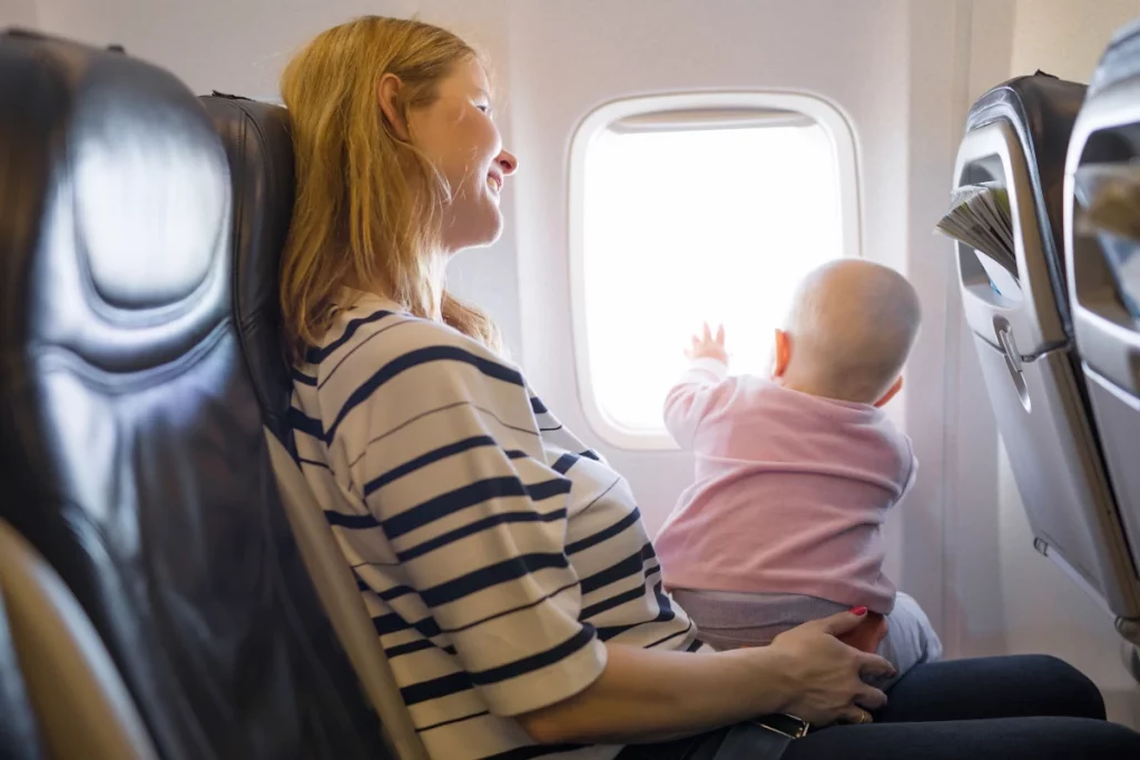 The Stork Bag - Practical Tips For Traveling With Your Toddler - woman holding baby on airplane